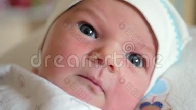 蓝色大眼睛的新生儿移动他的嘴，看着相机。 <strong>关爱</strong>儿童的理念.. 先看看